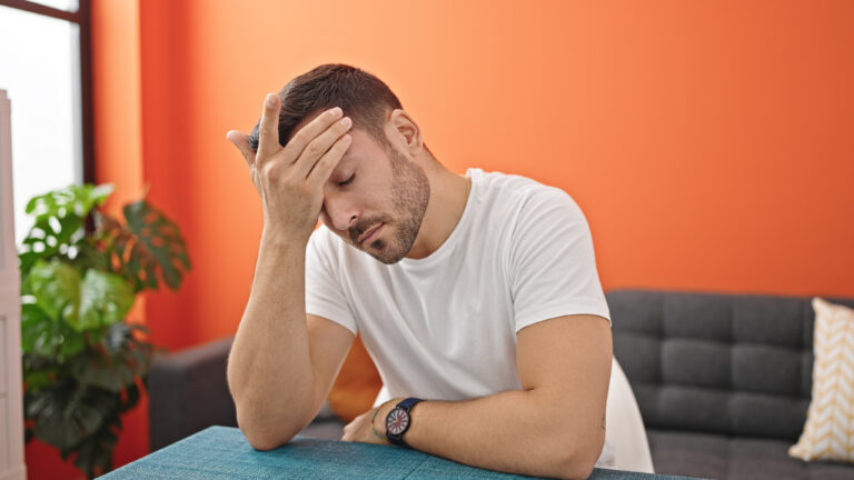 Hombre con signos de cansancio y sobrecarga emocional durante una jornada de trabajo