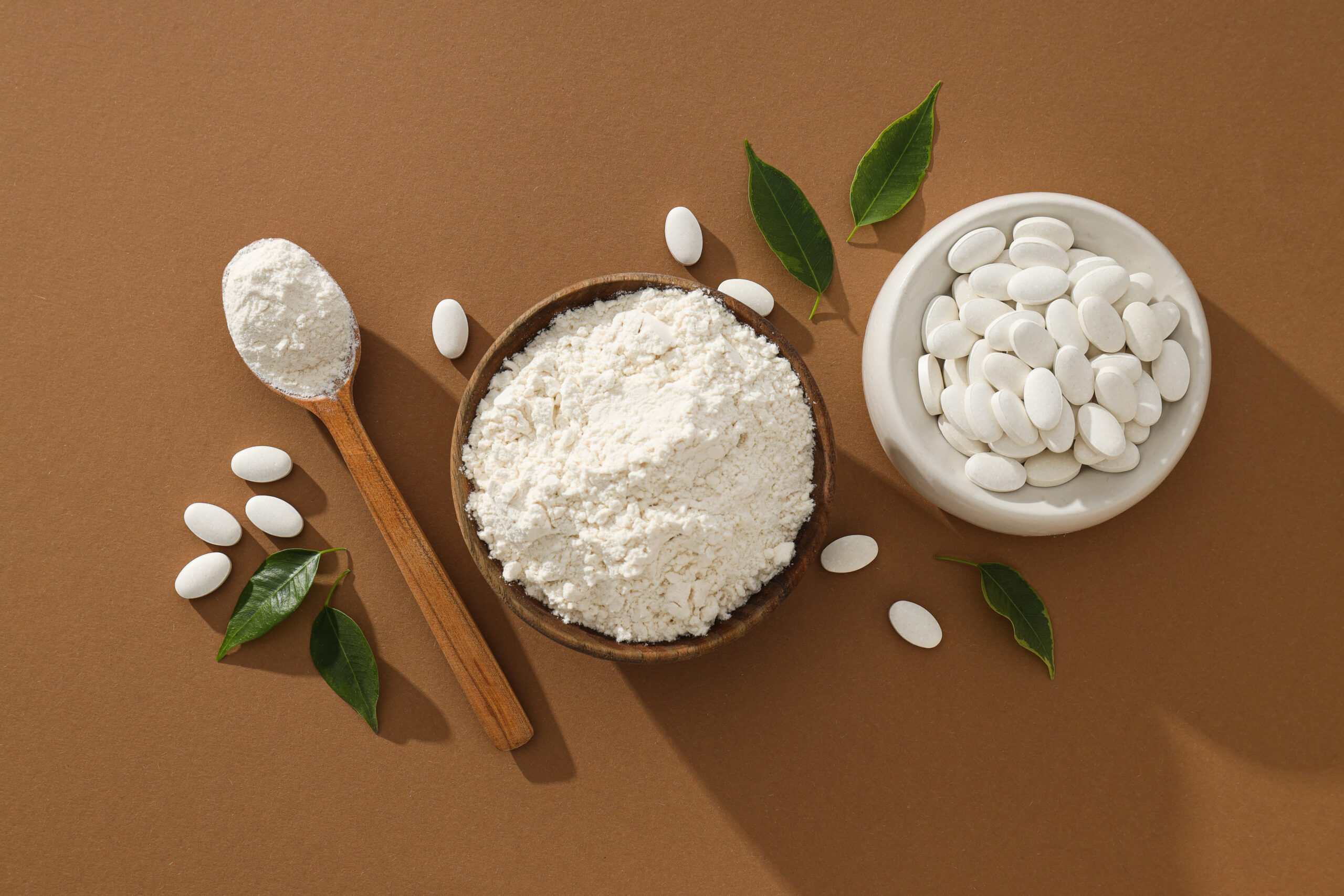Multivitamínicos en polvo al lado de unas pastillas de vitaminas.