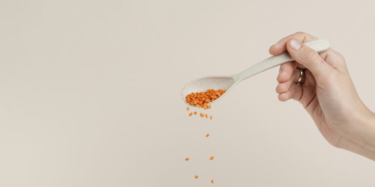 Multivitamínico en polvo presentado en cuchara dosificadora para complementar la alimentación diaria con vitaminas y minerales esenciales.
