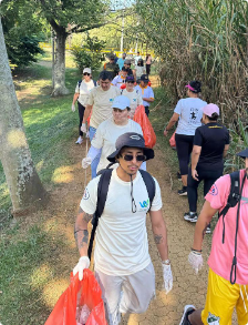 Colaboradores de JGB caminando por un sendero durante una jornada de limpieza ambiental, llevando bolsas para la recolección de residuos.