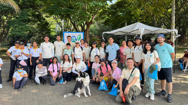 Grupo de voluntarios reunidos en un parque durante una jornada comunitaria de cuidado ambiental y trabajo en equipo, posando para una fotografía