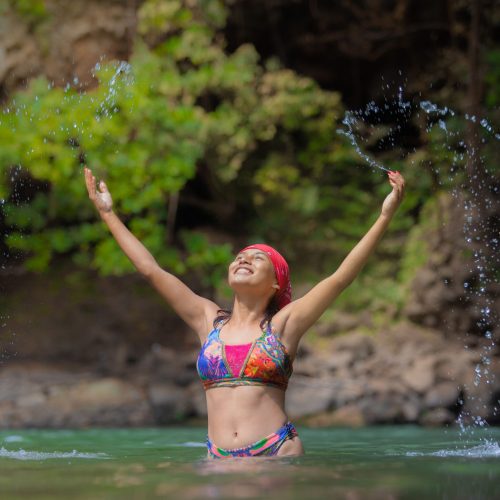 Mujer feliz en un lago natural mostrando una buena calidad de vida.